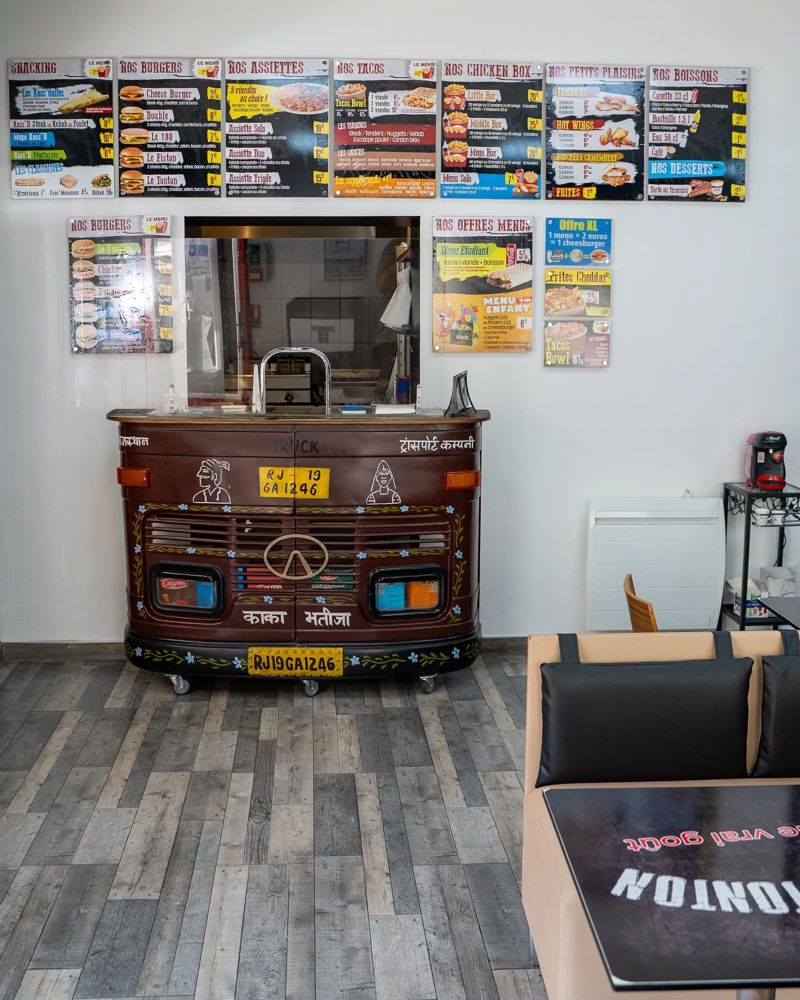 Salle de Chez Tonton avec les menus affichés au mur et le comptoir